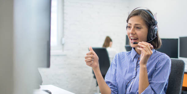 Vriendelijke vrouwelijke medewerker met headset tijdens intake gesprek – contact Horeca Essentie