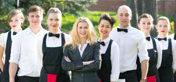 Professioneel horecateam in uniforme kleding met leidinggevende op de voorgrond